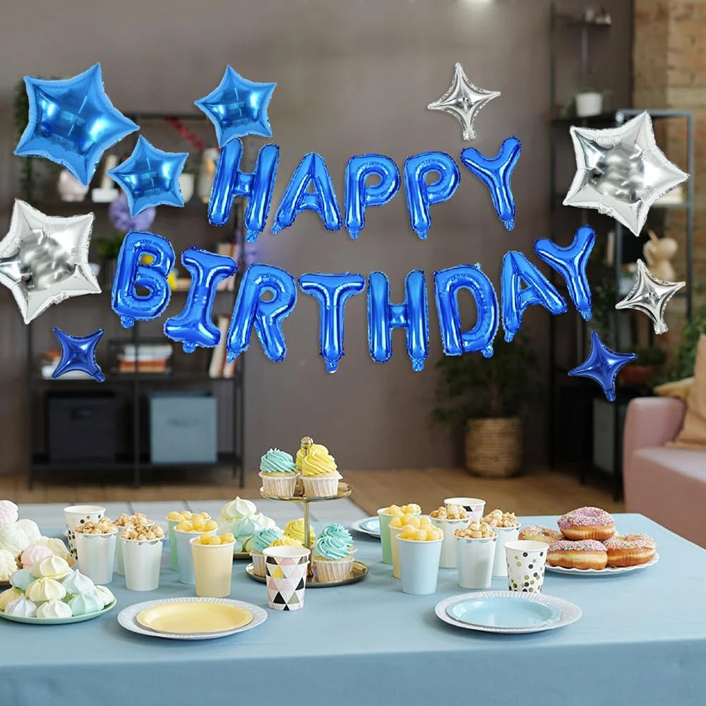 A silver and blue foil balloon banner spelling out Happy Birthday decorating a table with cupcakes and pastries.