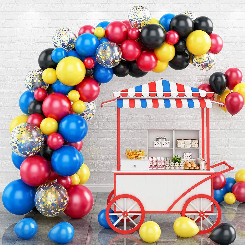 A balloon garland arch kit featuring colorful balloons and star foil accents displayed in a white booth setting.