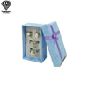 Caja de regalo azul claro con cuatro pendientes plateados.