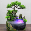Resin waterfall desktop fountain with LED lighting featuring a mossy rock landscape and glowing purple water.