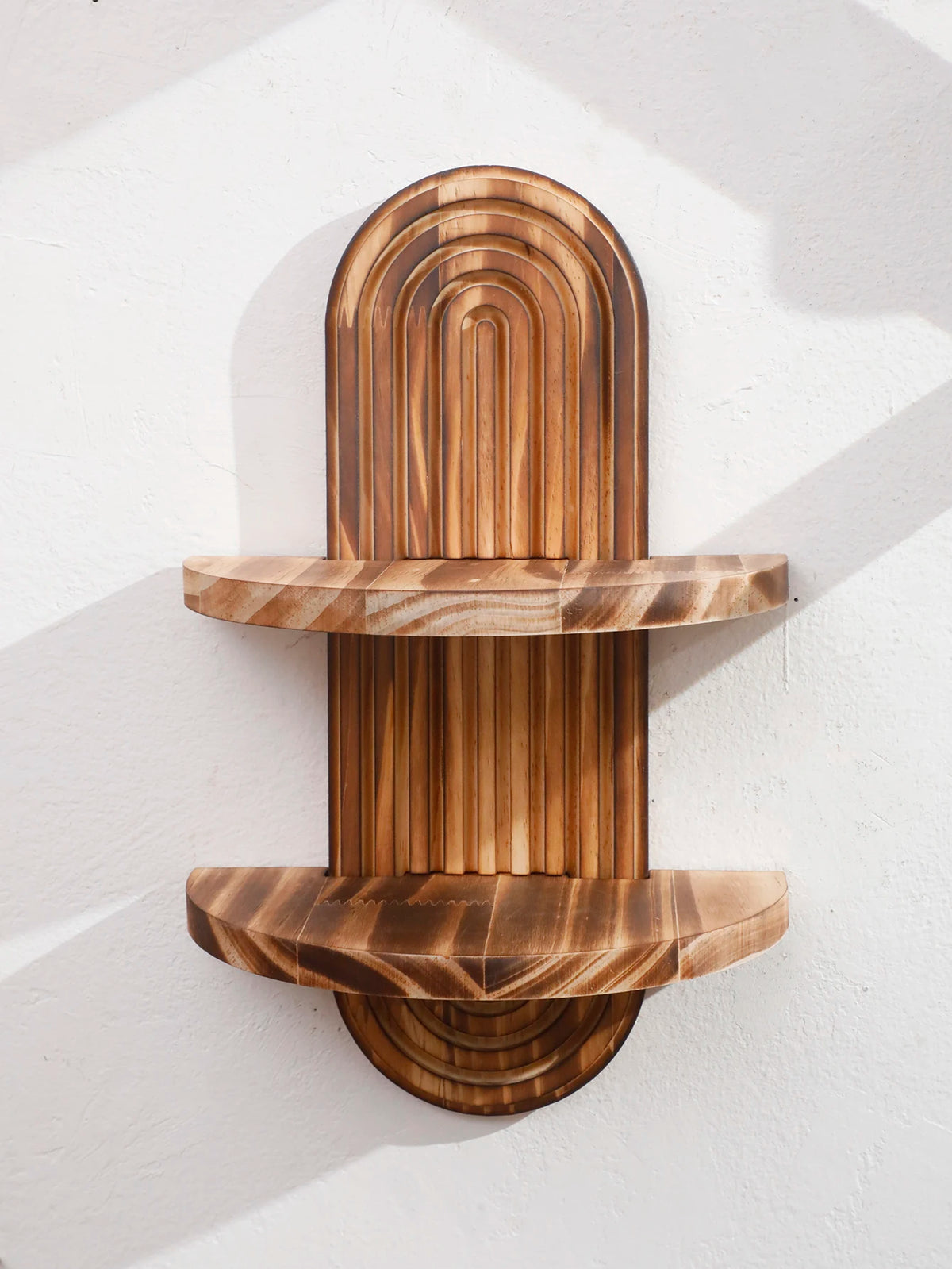 Two wooden wall shelves with a curved, natural wood grain design mounted on a white wall.