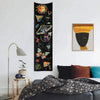 Dark tapestry featuring celestial elements like the sun, moon, and galaxy in yellow, orange, and green tones.