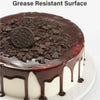 A round cake with a dark chocolate ganache coating and topped with crushed chocolate cookies.
