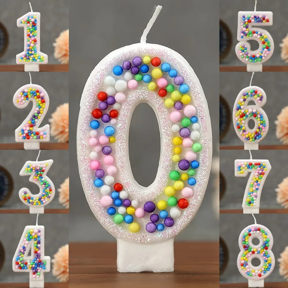 A glitter number candle shaped like zero decorated with colorful candy beads for a birthday celebration.