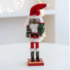 Handcrafted wooden nutcracker soldier figurine with a red hat, white beard, and green uniform