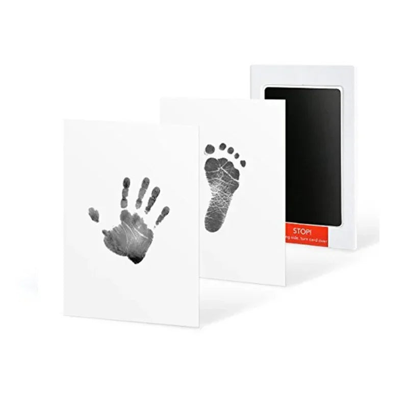 A white card featuring a dark handprint and footprint design next to a black frame.
