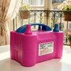 A pink electric balloon pump with blue accents resting on a white surface.