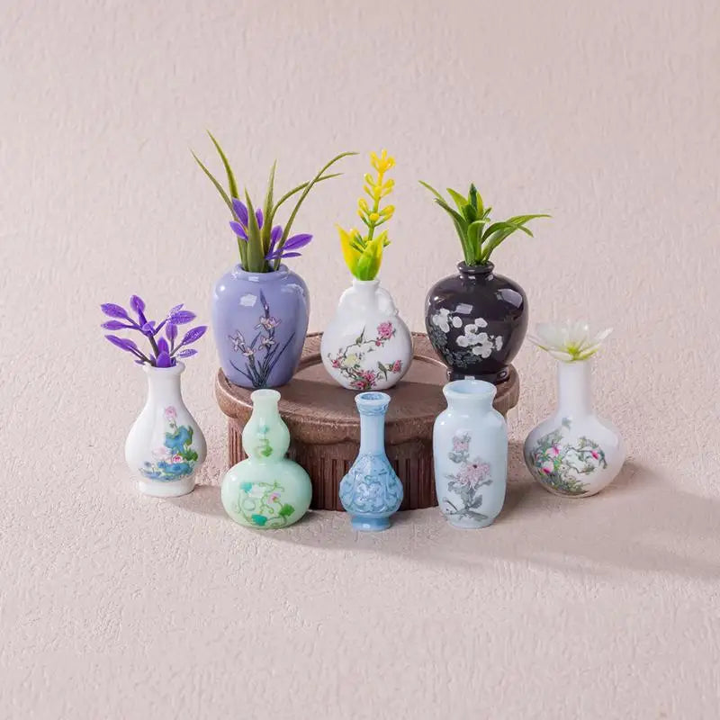 A set of eight mini resin vases with various floral patterns and colors displayed on a light pink surface.