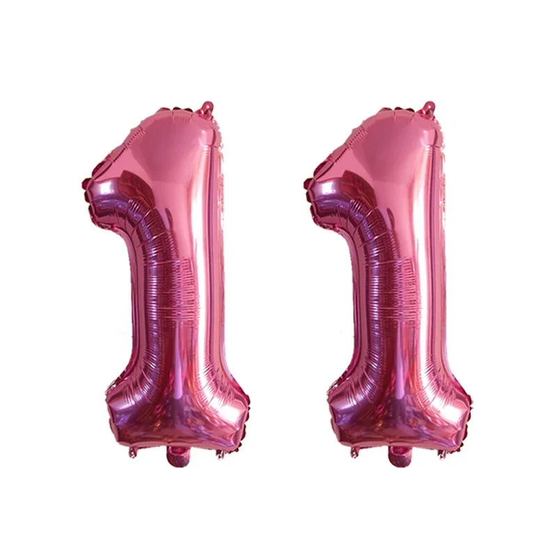 Two shiny metallic pink foil number balloons shaped like the number 1