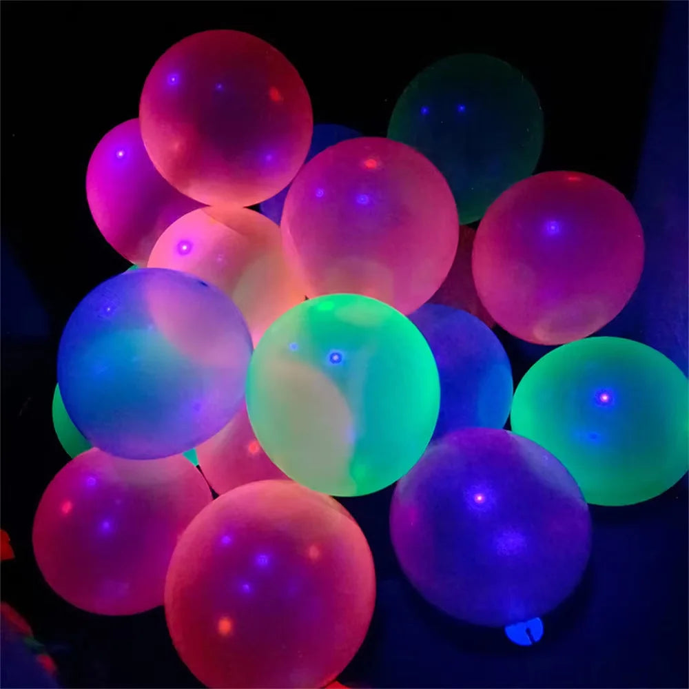 A cluster of neon glow latex balloons in various shades including pink, purple, and green against a dark background.
