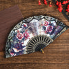 Spanish style folding lace trim handheld fan with floral patterns and black accents
