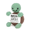 A handcrafted crochet dog doll with green skin and brown body, expressing love with a handwritten message.