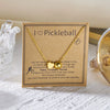 Gold necklace with a pickleball charm and inspirational text on a kraft paper card