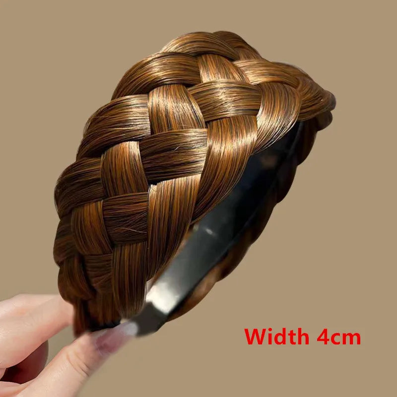 A close-up of a brown braided hair band with a gold sheen, shown being held by a hand.