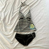 Black and white striped sleeveless top with a tie detail laid out on a white surface.