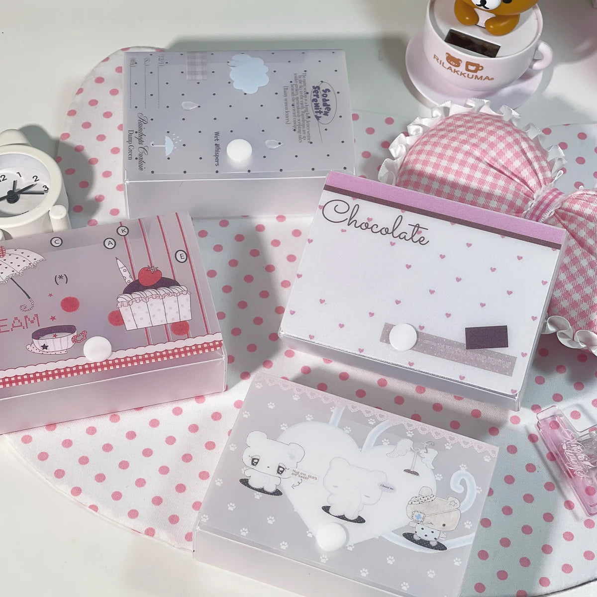 Colección de cajas de almacenamiento minimalistas para pegatinas y tarjetas en varios colores pastel y diseños.