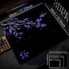 A black gaming mouse pad featuring a delicate purple cherry blossom branch design on a dark surface.