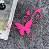 A bright pink vinyl butterfly sticker with swirling lines is placed on a gray, textured surface.