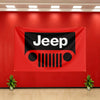 A red banner featuring the black Jeep logo displayed on a wall with potted plants below.