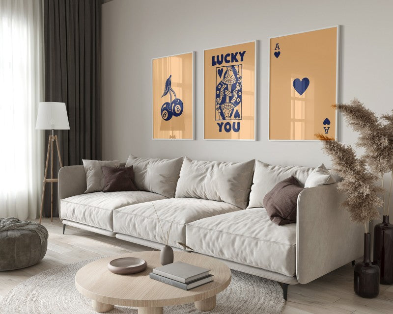 A modern living room featuring a light sofa, wooden coffee table, and framed art prints on the wall.