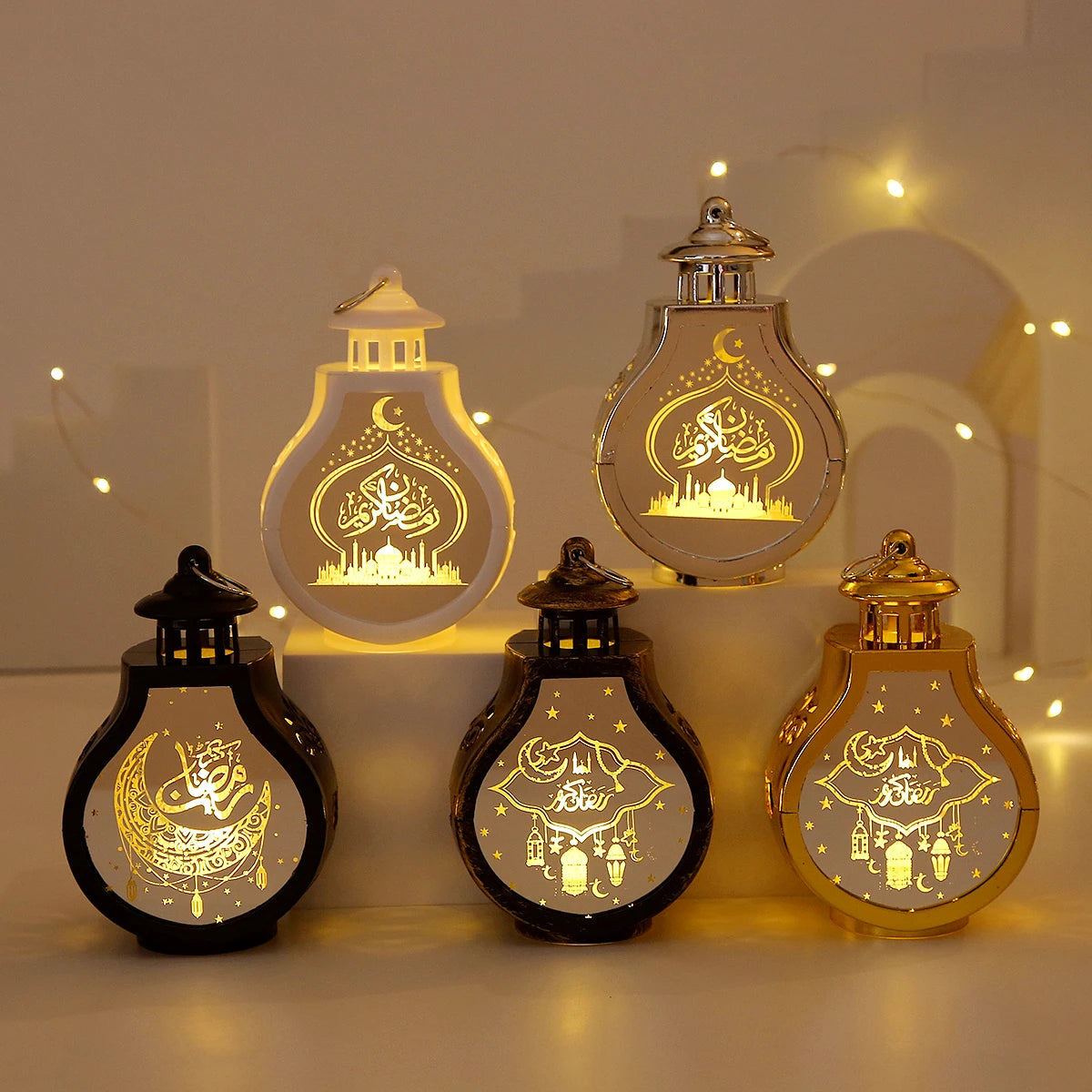 Three elegant gold LED star and moon lanterns displayed on a surface with soft lighting.