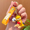 A hand holds a yellow Garfield cartoon keychain pendant with a gold chain and orange tag.