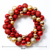 A circular wreath made of shiny red and gold Christmas ball ornaments.