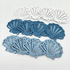 A set of twelve wooden ocean ornaments featuring various sea creatures like shells, scallops, and starfish in shades of blue-