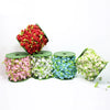 Assortment of floral garlands in various colors including red pink white and blue displayed in green tubes