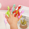 A hand holds several colorful dinosaur-shaped slingshot toys for kids' party favors