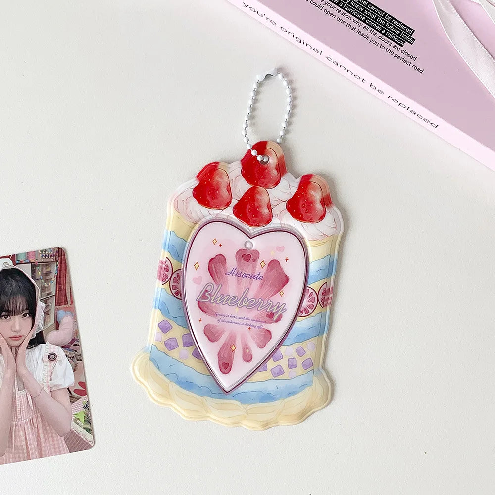 A pink and white cartoon strawberry bag keychain card holder with a heart-shaped charm.