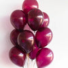 A cluster of glossy burgundy red latex balloons tied together for a celebration.