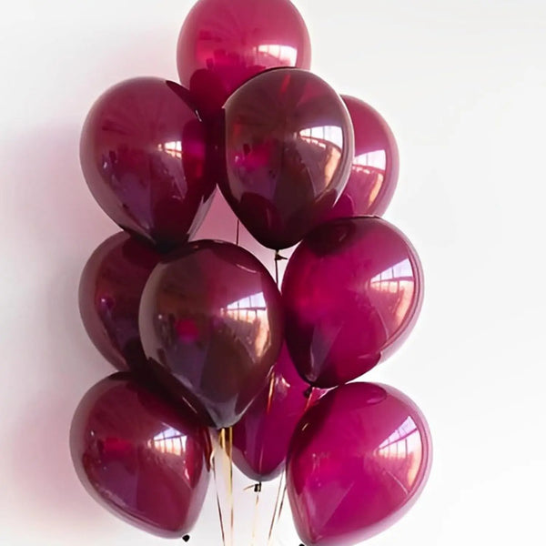 A cluster of glossy burgundy red latex balloons tied together for a celebration.