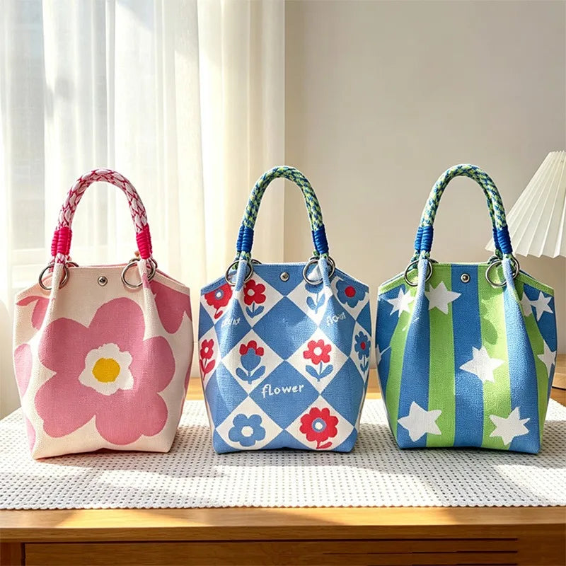 Three colorful jacquard knitted shoulder bags featuring floral and striped patterns displayed on a wooden surface.