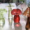 A collection of glass vases shaped like mushrooms in translucent jelly colors, including green and pink.