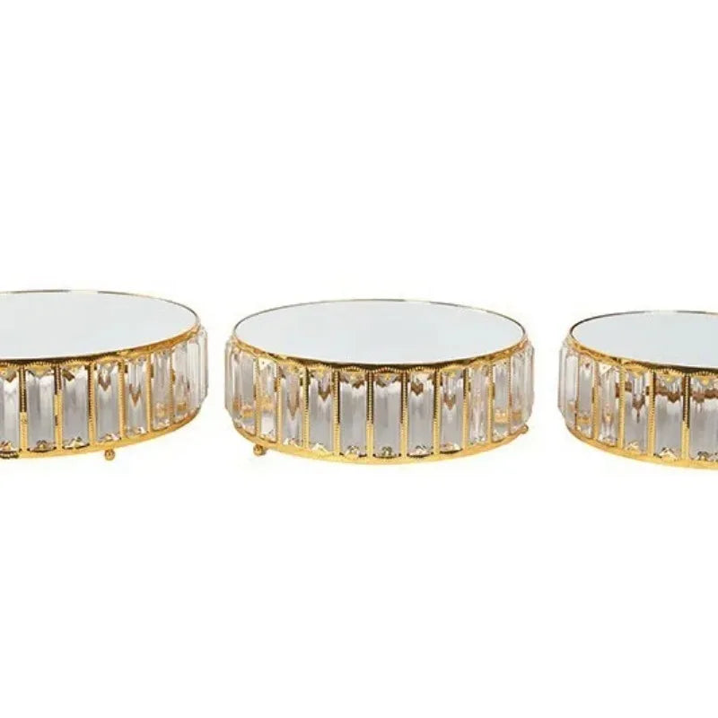 A set of three crystal and gold-edged metal cake stands.