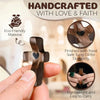 A hand holds a dark wooden pocket cross, handcrafted with love and faith, finished with food-safe tung oil for durability.