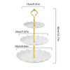 A two-tier gold serving stand with white scalloped plates for desserts and fruit.