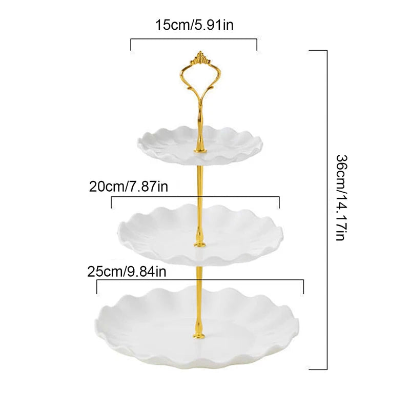 A two-tier gold serving stand with white scalloped plates for desserts and fruit.