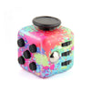 A colorful fidget cube with a pink, green, and blue marbled design and a black lid.