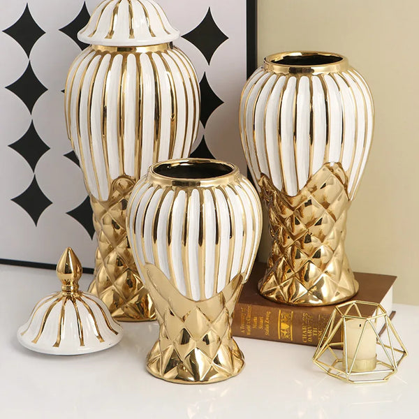 A set of handcrafted ceramic decorative vases in gold and white stripes, displayed on a white surface.
