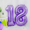 A purple foil number balloon shaped like the number 18 is displayed on a white surface.