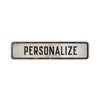 A rectangular, weathered metal sign with the word PERSONALIZE engraved on it.