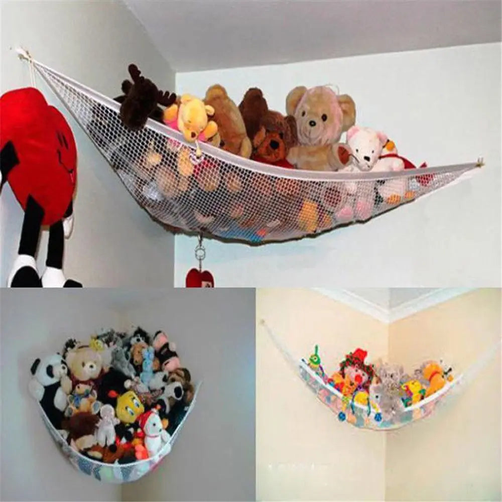 A mesh storage hammock filled with various stuffed animals is suspended against a white wall.