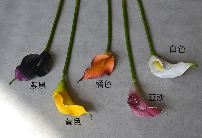 A collection of EVA artificial calla lily stems in various colors including black, orange, yellow, and white.