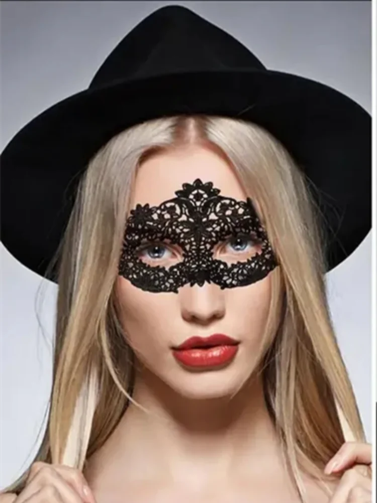 A blonde woman wearing a black wide-brim hat and a black lace eye mask for a masquerade event.