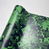 A close-up of a color-changing digital camouflage vinyl wrap film with green and black patterns.