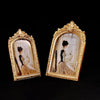 Two ornate gold-framed vintage resin photo frames displaying sepia-toned portraits.