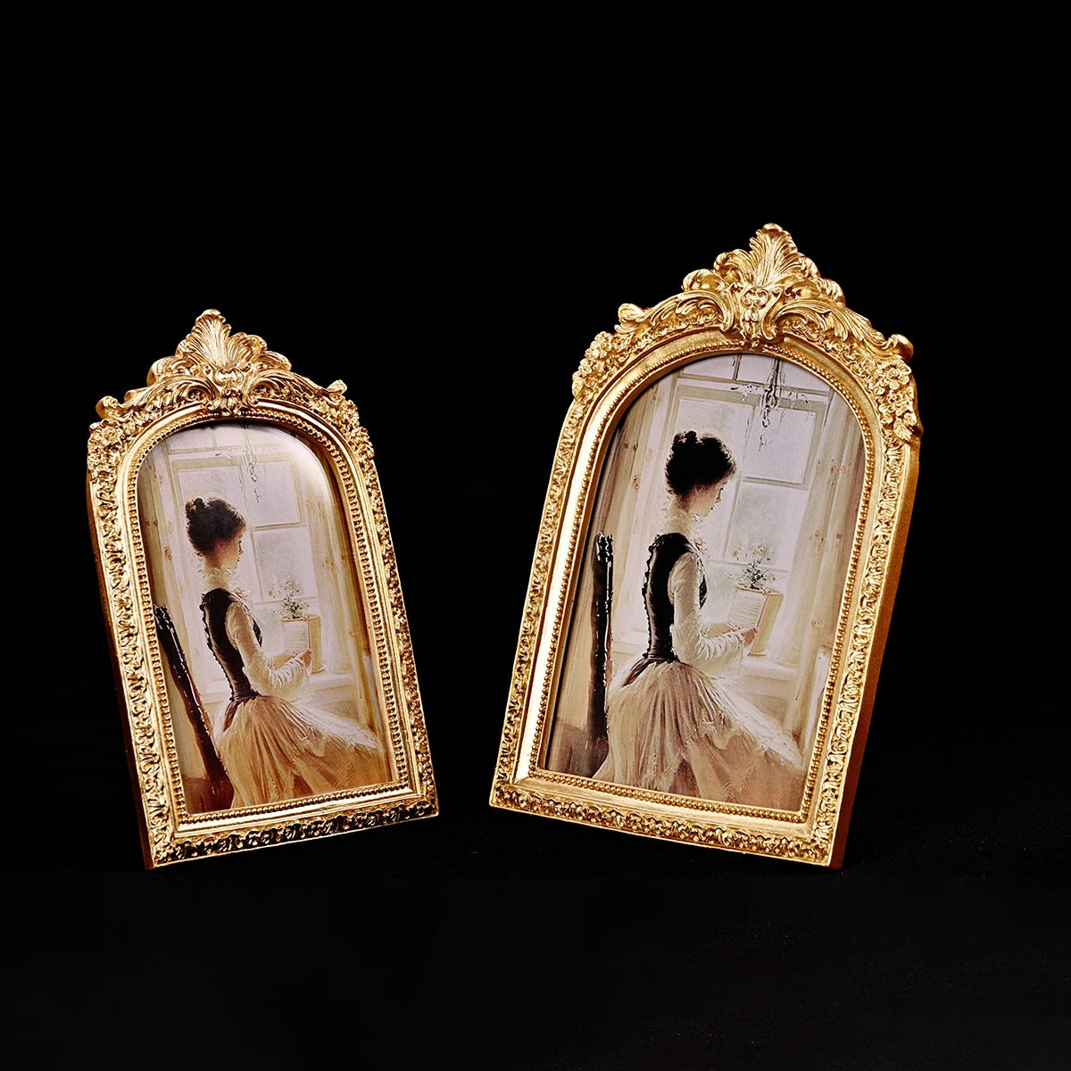 Two ornate gold-framed vintage resin photo frames displaying sepia-toned portraits.