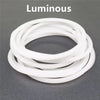A stack of ten luminous white silicone bracelets arranged in a circle.